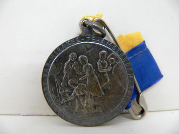 Medaille met lint, houdende een afbeelding van het Mirakel van Amsterdam. Met tekst op voorzijde: 'H. Sacrament-van-mirakel-te-Amsterdam-anno-1345' en tekst op achterzijde: 'Capel de H. stede'