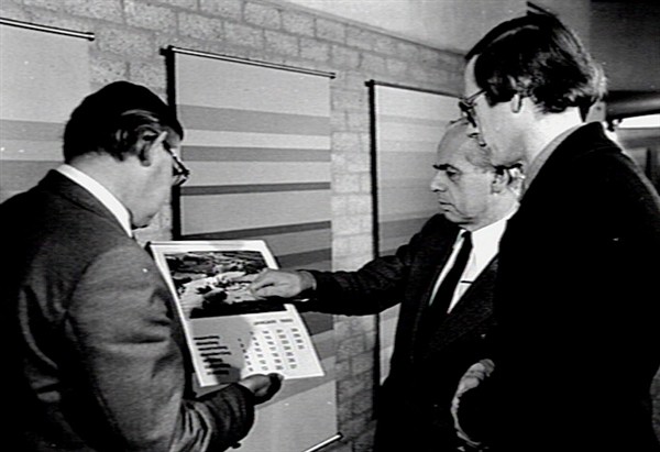 T.N.J.A. van Rijn, directeur A-Faculteiten (midden), bekijkt de nieuwe kalender (1980) met 12 luchtfoto's van het landgoed Heyendael en de KU van 1910 tot 1979, samen met de fotograaf Spaan (links)