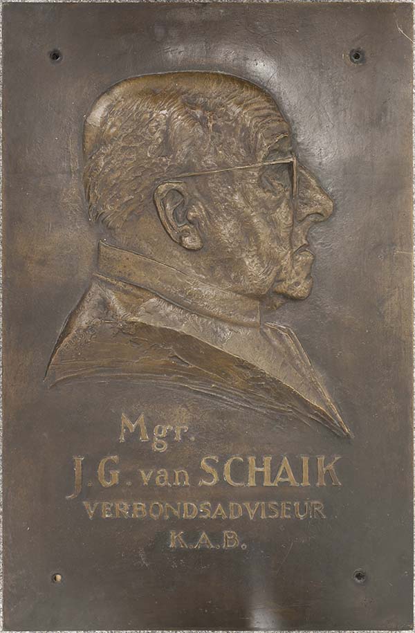 Bronzen plaquette van mgr. J.G. van Schaik, adviseur van de KAB, door Albert Termote. Net als de bronzen plaquette van A.C. de Bruijn kwam dit werk in het trappenhuis van het Huis van de Arbeid in Utrecht te hangen.