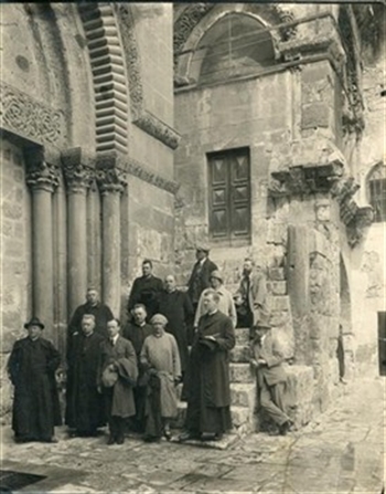 Pelgrims bij de Verrijzeniskerk in Jeruzalem, 1905. De geestelijke links vooraan is pastoor A.A. Suys. De elegante heren rechts -één leunt tegen de trap, één zit op de trap- zijn Piet Gerrits en J. Stuyt.